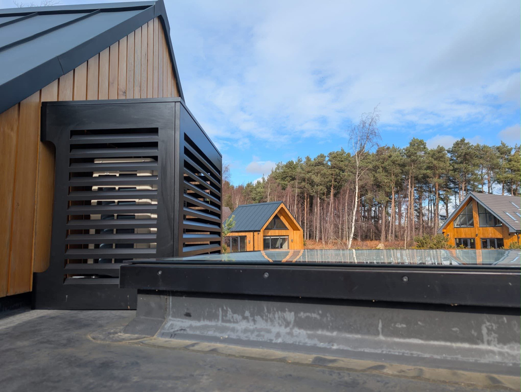 Louvred condenser housing on a lodge roof